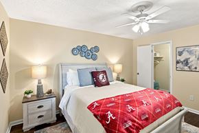 Tuscaloosa apartment for rent - A bedroom with a bed covered in a red Alabama football bedspread.