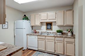 Tuscaloosa apartment for rent - A kitchen with a white refrigerator and cabinets.