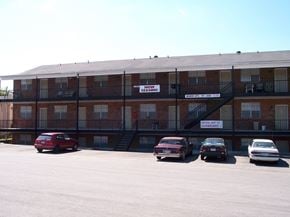 Tuscaloosa townhouse for rent - A red car is parked in front of a brick apartment building.