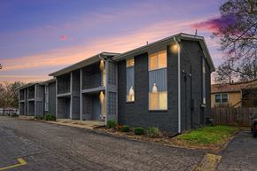 Raytown apartment for rent - A grey building with a parking lot in front of it.