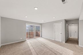 Warrensburg apartment for rent - A spacious room with a carpeted floor and sliding glass doors.