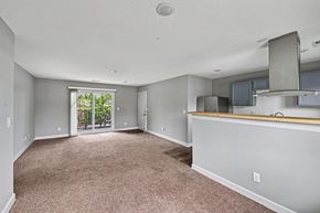 Raytown apartment for rent - A spacious living room with a carpeted floor and a bar area.