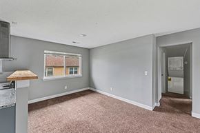 Raytown apartment for rent - A room with a window and a door leading to another room.