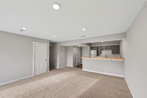 Warrensburg apartment for rent - A spacious room with a kitchenette and a door leading to another room.
