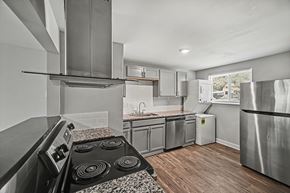 Kansas City townhouse for rent - A modern kitchen with a stove top oven and a refrigerator.