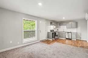 Independence apartment for rent - A kitchen with stainless steel appliances and a window with a view of a fence and trees.