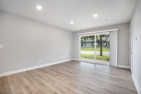 Kansas City apartment for rent - A room with wooden flooring and a sliding glass door leading to a balcony.at Palisades Apartments, Kansas City, MO 64133