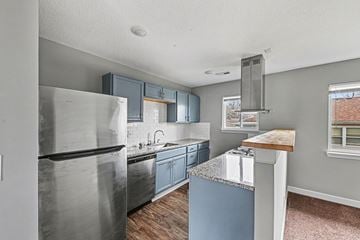 Raytown apartment for rent - A kitchen with a stainless steel refrigerator and blue cabinets.