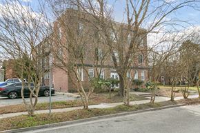 Newport News apartment for rent - A large brick building with a tree in front of it at Shipyard Shores Apartments, Apartments, Newport News, VA