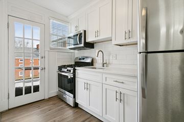 Newport News apartment for rent - A kitchen with white cabinets and a stainless steel refrigerator.