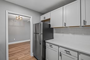 Tallahassee apartment for rent - A kitchen with a black fridge and white cabinets. at Serenity Place Central, Tallahassee, Florida