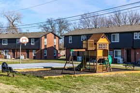 Kansas City apartment for rent - A playground with a basketball hoop and a wooden swing set. at Blacklark Apartments, Kansas City, KS, 66101