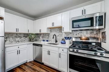Baltimore apartment for rent - A kitchen with white cabinets and a black stove top.