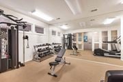 Riverside apartment for rent - A gym with a variety of equipment including weights, a bench, and a treadmill at The Aspens Riverside, Riverside, 92504