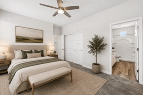 Phoenix apartment for rent - A bedroom with a bed, a bench, a ceiling fan, and a painting on the wall.