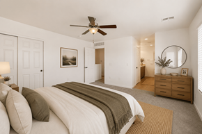 Tucson apartment for rent - A bedroom with a large bed and a ceiling fan.