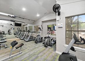 Dallas apartment for rent - a gym with a lot of exercise equipment and a window at Heatherstone, Dallas, TX, 75287