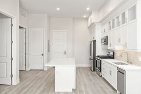 San Diego apartment for rent - a long hallway with white cabinets and white walls and floors and a white counter top