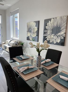 San Diego apartment for rent - a dining room with a glass table and chairs and paintings on the wall