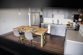 Beloit apartment for rent - A kitchen with a table and chairs in the foreground and a refrigerator in the background.