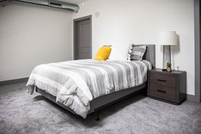 Beloit apartment for rent - A bedroom with a bed, nightstand, and lamp.