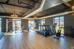 Lemont apartment for rent - a gym with fitness equipment and windows in a building with wood floors
