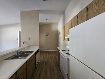 Bay Point apartment for rent - A kitchen with a white fridge, sink and wooden cabinets.