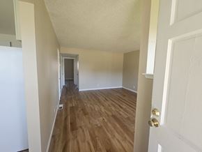 Antioch apartment for rent - A hallway with wood floors and white walls.