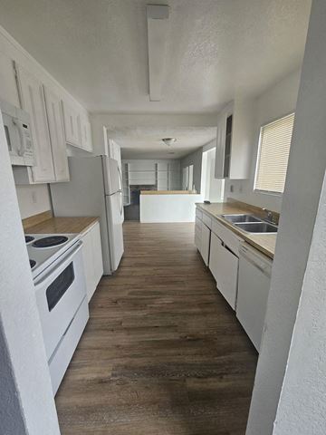 Bay Point apartment for rent - A kitchen with white cabinets and a wooden floor.