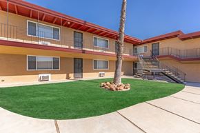 Antioch apartment for rent - A building with a red roof and a palm tree in front.