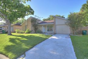 Pearland apartment for rent - a driveway in front of a house with a lawn and trees
