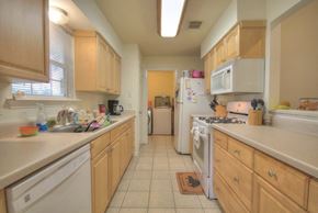 Pearland apartment for rent - a kitchen with white appliances and wooden cabinets