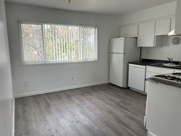 Antioch apartment for rent - A kitchen with white appliances and a window with blinds.
