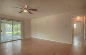Pearland apartment for rent - a living room with a ceiling fan and a wood floor
