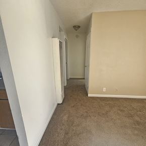 Antioch apartment for rent - A long hallway with carpeted floors and white walls.