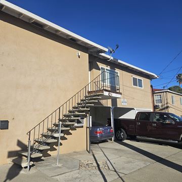 Antioch apartment for rent - A tan building with a red truck parked in front.