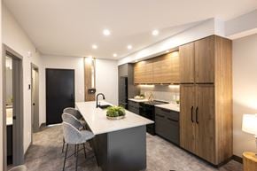 Calgary apartment for rent - A modern kitchen with a dining table and chairs.