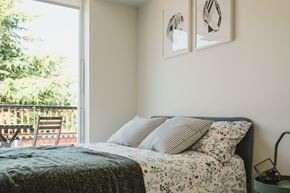 Seattle apartment for rent - A bedroom with a bed, pillows, and two framed pictures on the wall.
