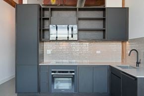 Chicago apartment for rent - a kitchen with black cabinets and a sink and a stove