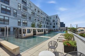 Chicago apartment for rent - A pool area with chairs and a train-like structure.