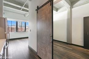 Chicago apartment for rent - a sliding barn door in an empty room with a window