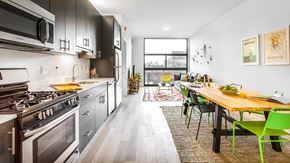 Chicago apartment for rent - a kitchen with stainless steel appliances and a wooden table with green chairs