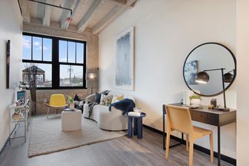 Chicago apartment for rent - A living room with a yellow chair and a desk with a lamp.