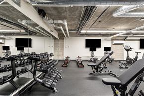 Chicago apartment for rent - A gym with a variety of equipment including dumbbells, benches, and exercise bikes.