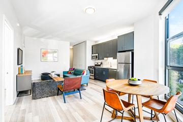 Chicago apartment for rent - a living room with a table and chairs and a kitchen with stainless steel appliances