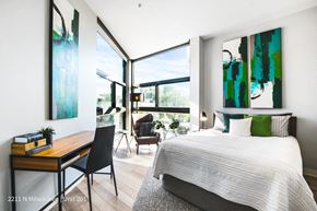 Chicago apartment for rent - a bedroom with a bed and a desk and large windows