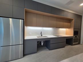 Cleveland apartment for rent - A modern kitchen with a refrigerator on the left and a counter with a sink in the middle.