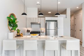 Chicago apartment for rent - A modern kitchen with white chairs and a white counter.