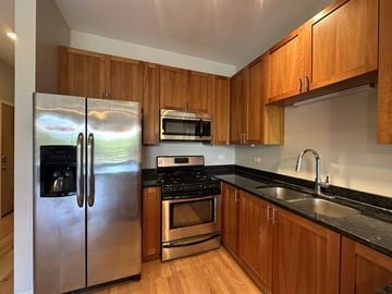 Chicago apartment for rent - A kitchen with wooden cabinets and a stainless steel refrigerator.