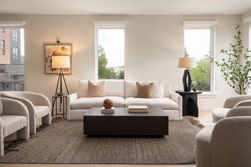 Rocky River townhouse for rent - A living room with a white couch, a brown rug, and a painting on the wall.